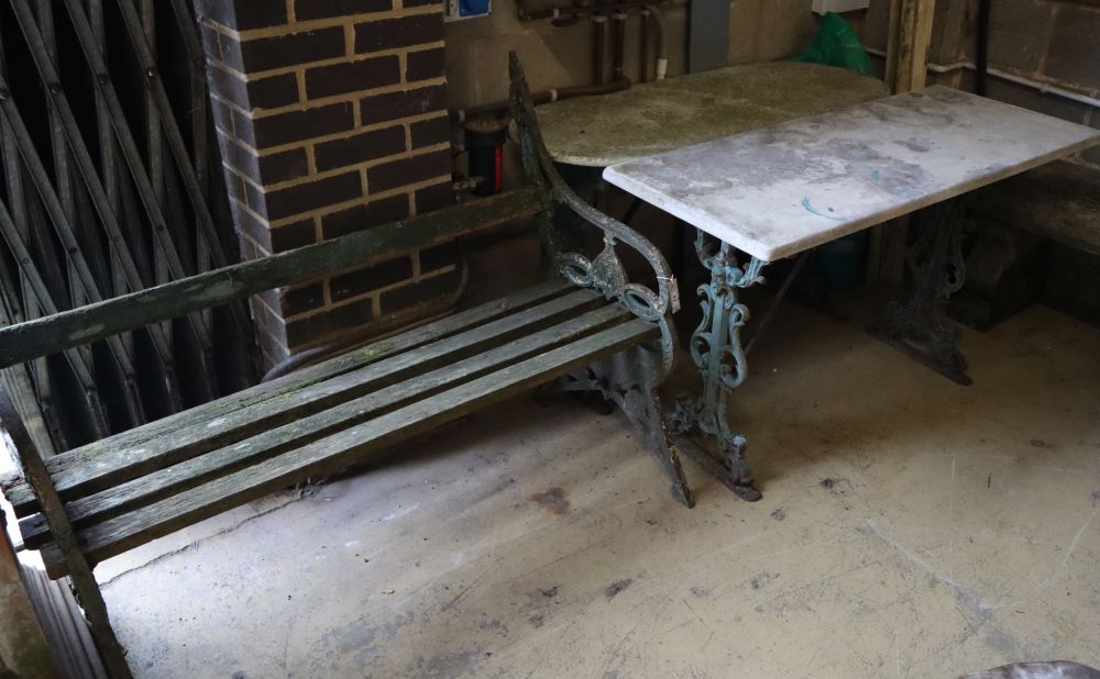 A Victorian painted cast iron slatted garden bench, width 126cm together with two cast iron marble top garden tables